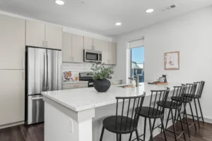 Apartment kitchen with quartz island and stainless steel appliances at 445 Park Commons