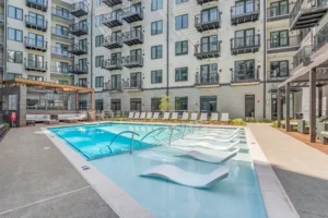 Saltwater pool with sun shelf loungers at 445 Park Commons apartments in Nashville